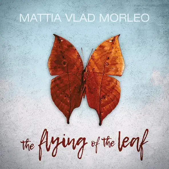 Brown leaf shaped like a butterfly on a textured background with text "MATTIA VLAD MORLEO" and "the flying of the leaf.